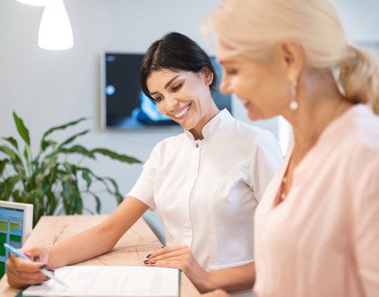 Smiling dental assistant showing patient forms