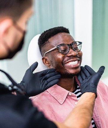 Dentist looking at smiling's patients teeth