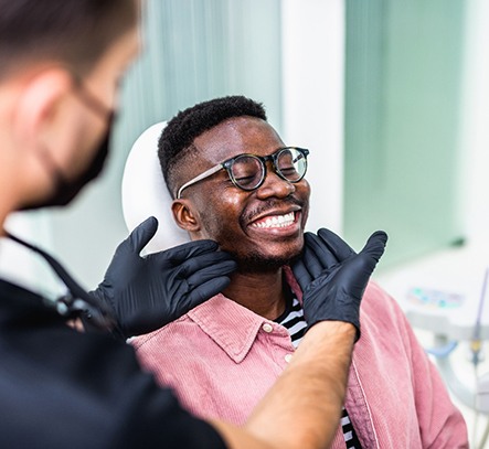 Dentist looking at patient's smile in treatment room